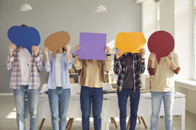 Group of people holding empty colorful speech balloons for your message or opinion Group of people holding empty colorful speech balloons for your message or opinion